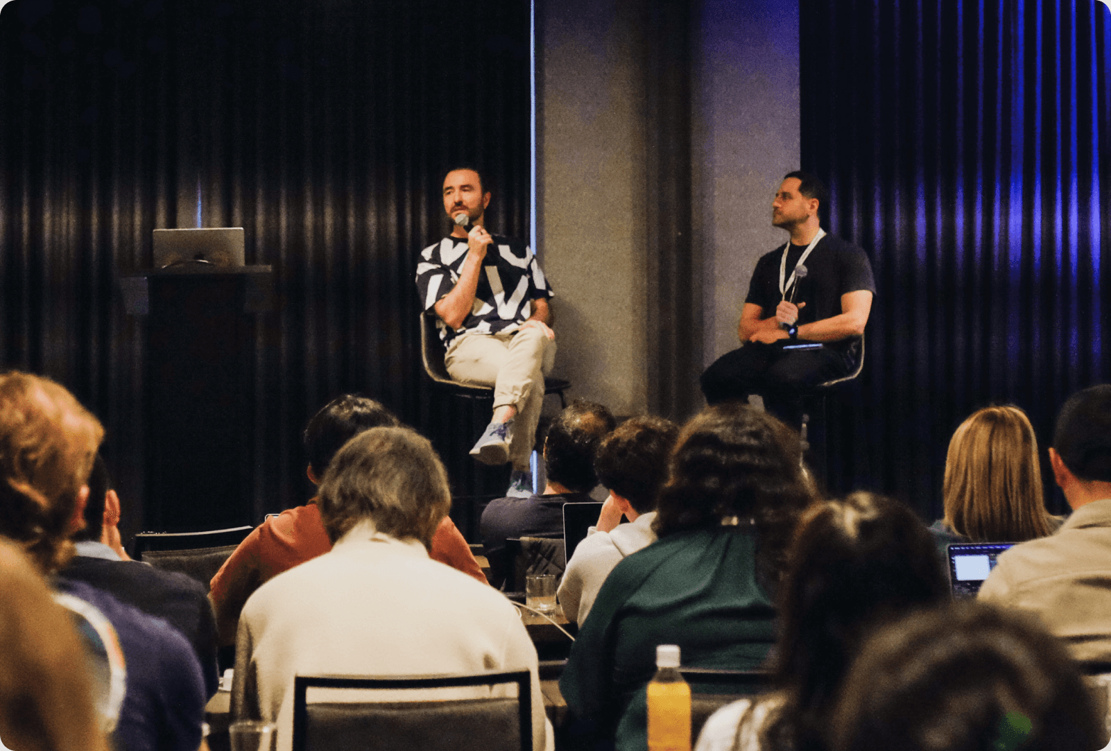 Two speakers on stage at a Collective event, facing the audience