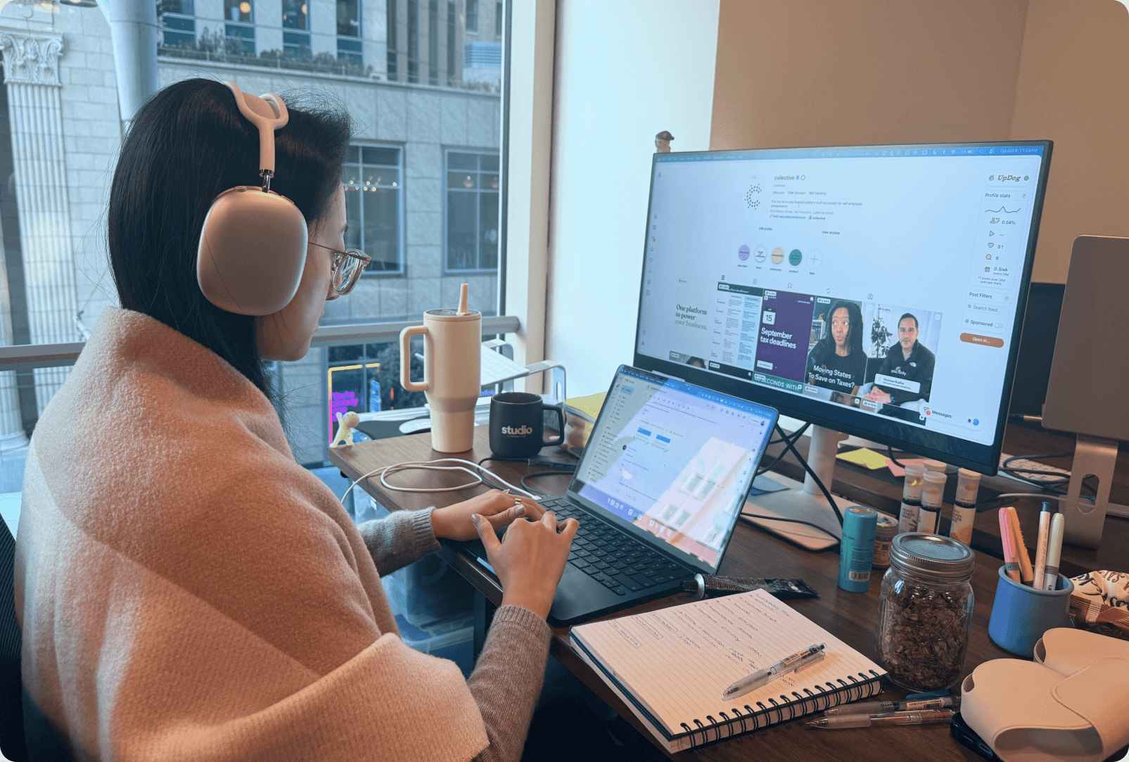 A Collective team member in headphones working at her desk